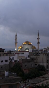 King Hussein Mosque rises above Madaba, Jordan beneath dramatic cloudy skies that slowly begin to dissipate and clear, vertical time lapse