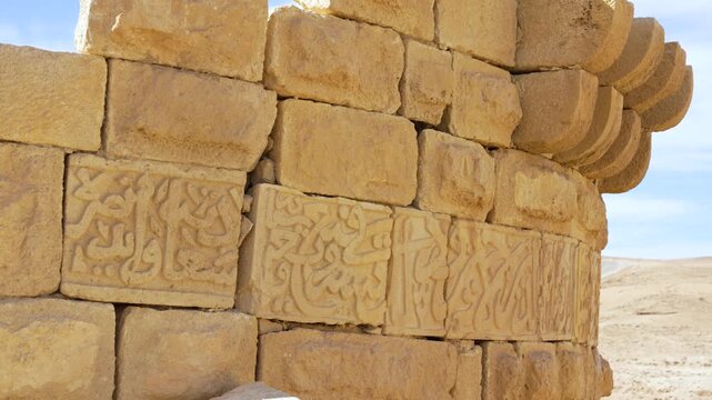 Close-up detailed view of the ancient carved stone reliefs of Shobak Castle incorporated into a weathered sandstone fortress wall inside, Middle East, Jordan