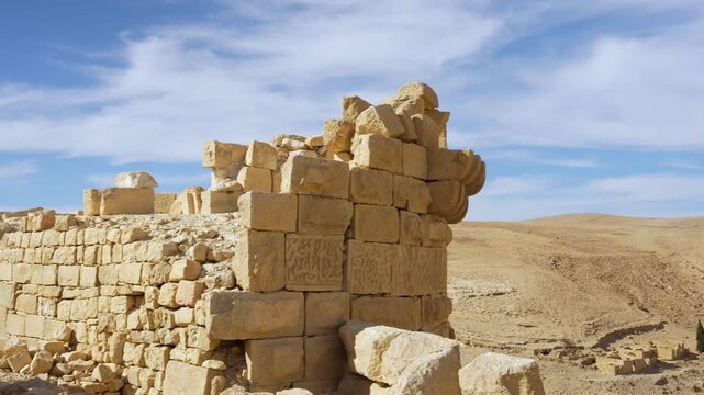 Detailed panning view of weathered stone walls and carved masonry inside Shobak Castle near Shobak, Jordan, revealing the medieval Crusader fortress ruins against the arid landscape