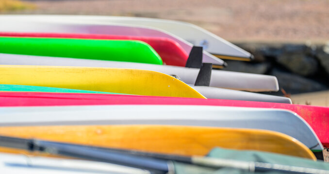 Abstract layers of colorful boat hulls in sunlight.