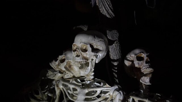 Close-up of a hanging skull garland at night. Plastic skulls on a rope create spooky Halloween decor.