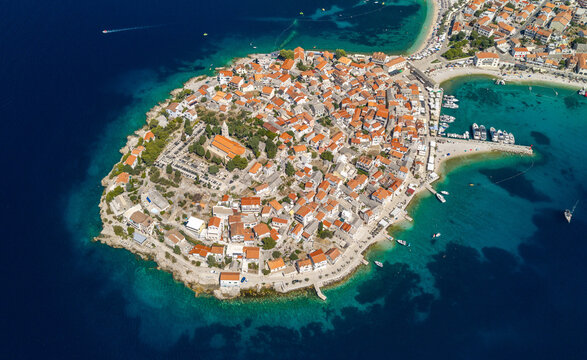 Aerial panoramic view of Primo&scaron;ten, Croatia, showing the historic peninsula, red rooftops, turquoise Adriatic waters, beaches, marina, surrounding islands and rugged Mediterranean coastline.