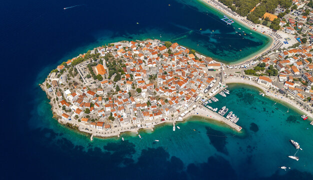 Aerial panoramic view of Primo&scaron;ten, Croatia, showing the historic peninsula, red rooftops, turquoise Adriatic waters, beaches, marina, surrounding islands and rugged Mediterranean coastline.