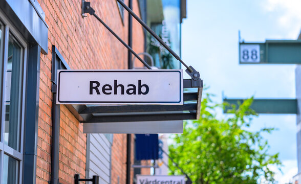 Trollh&auml;ttan, Sweden - August 22 2026: Rehabilitation clinic sign mounted outside brick healthcare building in Sweden.