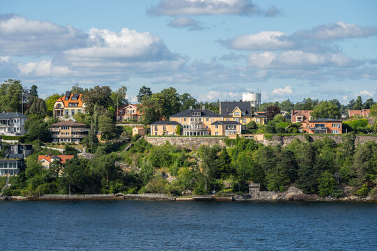 Stockholm, Sweden - August 04 2025: Colorful hillside houses above blue coastal water.