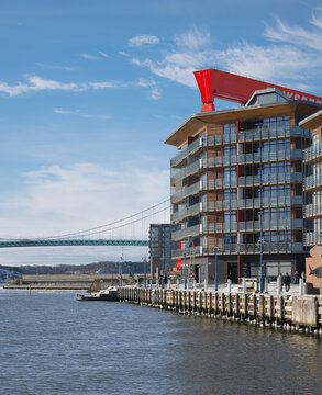 Modern waterfront building near bridge on calm winter day.