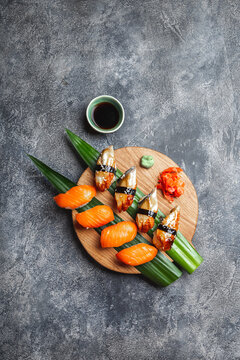 Sashimi sushi set on wooden board. Stone background. Top view