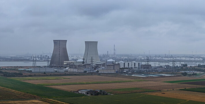 Beveren-Kruibeke-Zwijndrecht, Belgium - 18 August 2026: Aerial view of Doel Nuclear Power Plant with cooling towers, industrial facilities, and power lines near agricultural fields.