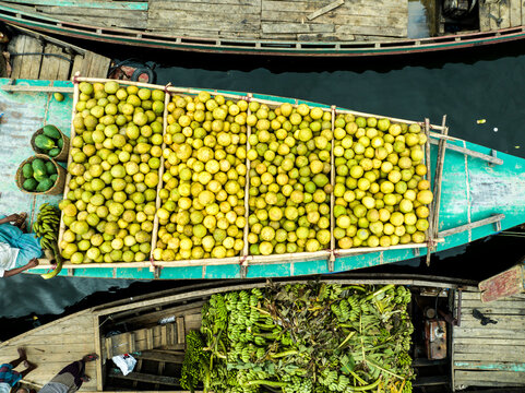 Rangamati Hill District, Bangladesh - 30 September 2023: Aerial view of Kaptai Lake with wooden boats heavily loaded with pomelos and bananas, reflecting local trade.