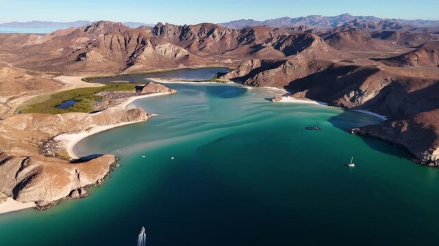 Wide drone landscape view of turquoise sandbars, shallow waters and mountains in Balandra Mexico