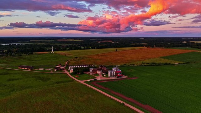 Aerial view of a grain elevator and farm fields during a vibrant colorful sunset in Michigan, USA