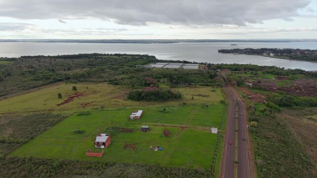 Scattered residential plots line the landscape beside Arroyo Martires, Posadas, Misiones, Argentina, drone forward flyover.