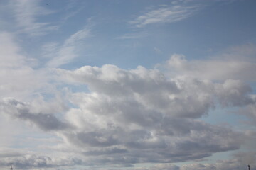 Fototapeta premium A wide scenic view of a bright blue sky filled with textured white and grey clouds during daytime.