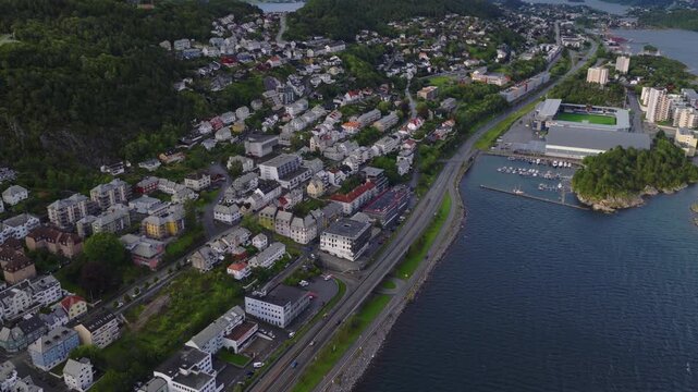 Aerial view of coastal town with marina and forested hillside  Norway, Alesund