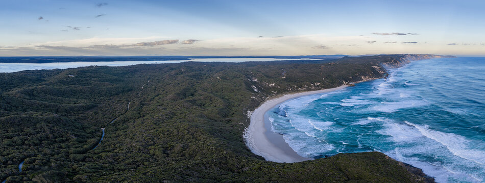 Aerial view of the Nullaki coastline featuring a pristine sandy beach, dense native forest, and turquoise waves crashing against the shore in Nullaki, Western Australia, Australia.