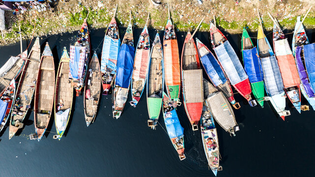 Aerial view of colorful wooden boats docked along the riverbank in Tongi, Dhaka Division, Bangladesh.