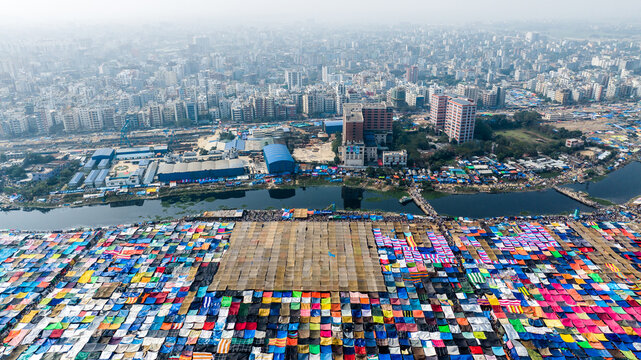 Aerial view of the massive Bishwa Ijtema gathering with colorful tents and temporary structures along the riverbank in Tongi, Dhaka Division, Bangladesh.