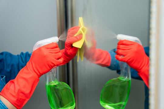 Washes the mirror with a cloth and detergent