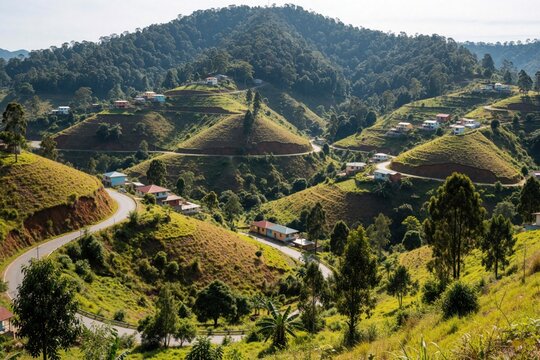 Rich green hills dotted with houses and winding roads under a clear sky. This landscape offers a serene view of rural life nestled within rolling terrain, showcasing natural beauty.