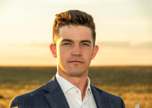 Portrait of a man in a suit outdoors at sunset