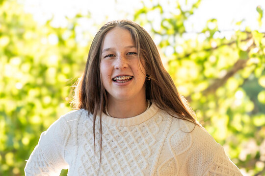 Smiling girl in white knitted sweater outdoors