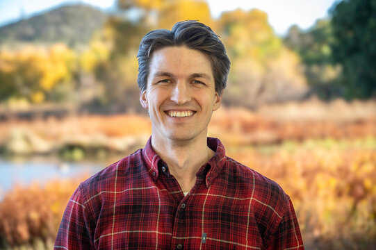 Smiling man in plaid shirt outdoors