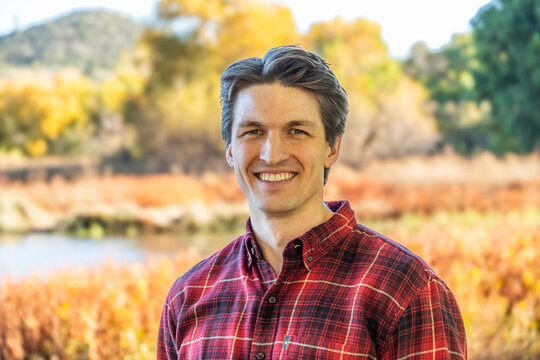 Smiling man in plaid shirt outdoors