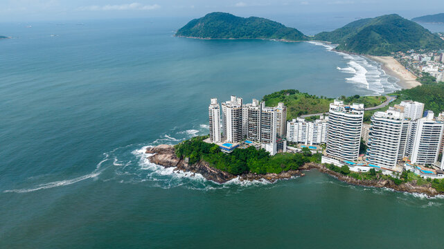 Aerial view of Ponta das Galhetas featuring modern high-rise residential buildings perched on a rocky headland overlooking the Atlantic Ocean in Guaruja, Sao Paulo, Brazil.