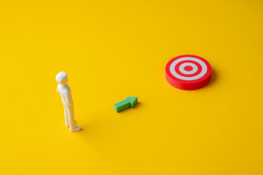 Goal setting and achievement concept with person following arrow toward target