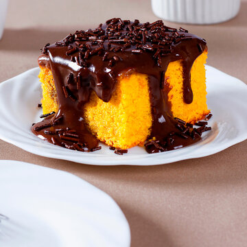 Brazilian carrot cake with a soft crumb, generous chocolate frosting, and chocolate sprinkles.