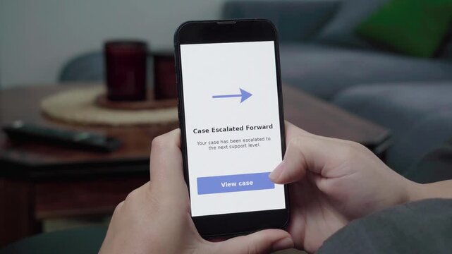 Person relaxes on a couch checking a Case Escalated Forward status screen with a View case action on a mobile support app.