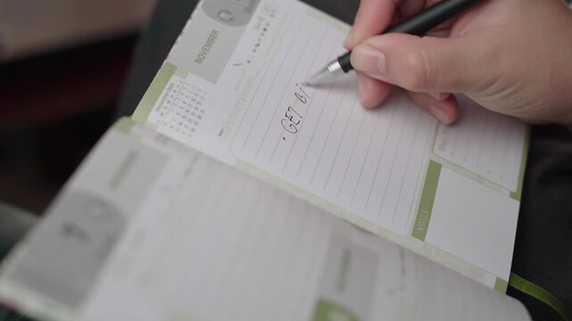 Calm indoor scene as a pen writes a birthday gift shopping task on a lined November diary page.