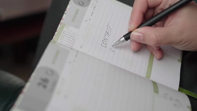 Woman notes a task to contact her insurance provider about policy coverage in a November weekly planner.