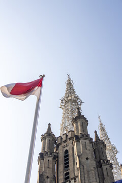 The Cathedral of Our Lady of the Assumption stands beside the Indonesian flag,