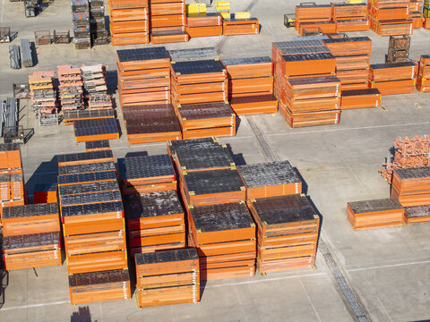 Jaworzno, Poland - 09 August 2026: Aerial view of PERI Polska Sp. z o.o. construction site featuring stacks of orange formwork panels and industrial equipment in a storage yard.