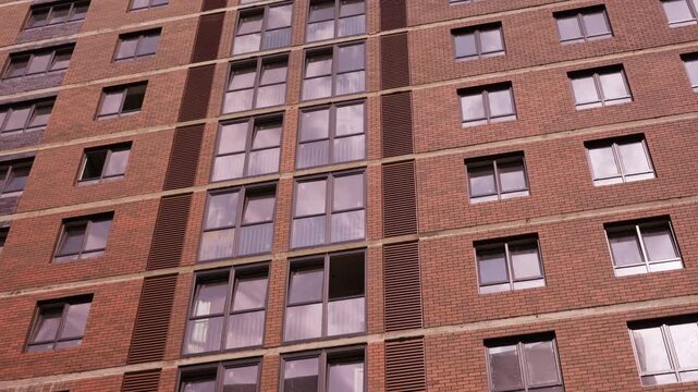 Partially installed windows on brick residential building facade