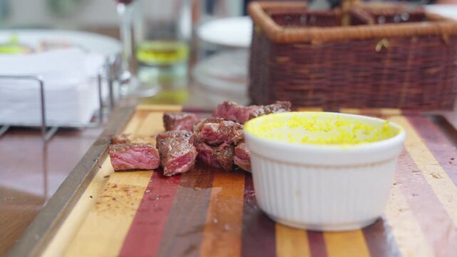 Person eating grilled steak with farofa at barbecue