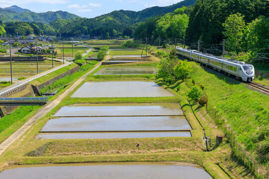 田植えの準備が進む横を城崎に向け駆け抜ける山陰本線の特急列車