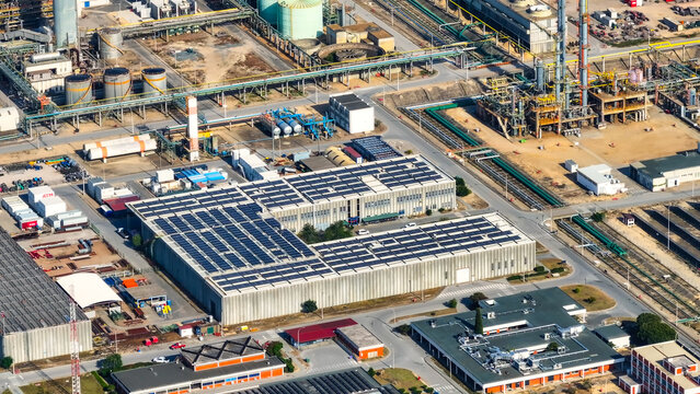 Aerial view of a large industrial manufacturing complex and oil refinery featuring extensive solar panel installations on rooftops in Sines, Setubal, Portugal.