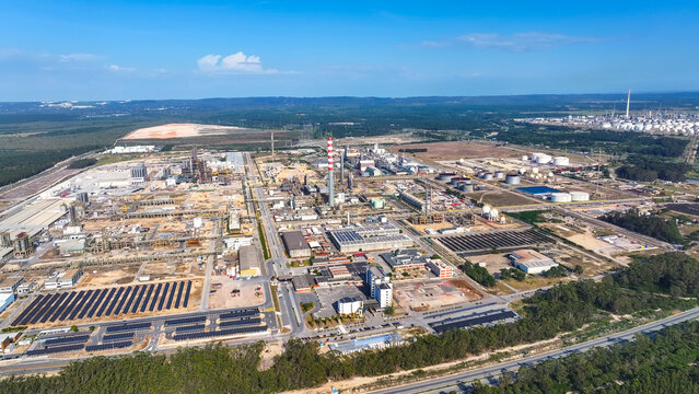 Aerial view of the large oil refinery and industrial manufacturing complex featuring storage tanks, solar panel arrays, and extensive infrastructure in Sines, Setubal, Portugal.