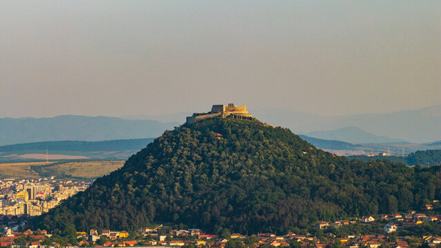 Aerial view of Deva Fortress perched atop a forested hill overlooking the city of Deva, Hunedoara, Romania.