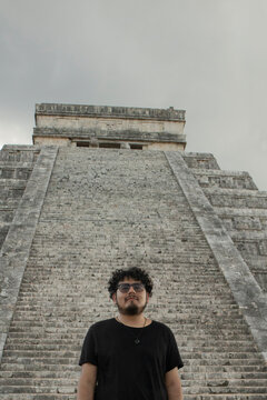 A traveler is standing in front of the pyramid of Chichen Itza in Yucatan, Mexico
