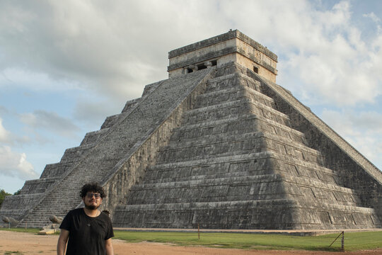 A traveler is standing in front of the pyramid of Chichen Itza in Yucatan, Mexico