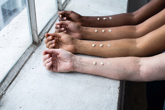 Sunscreen Swatches on Diverse Arms by a Window