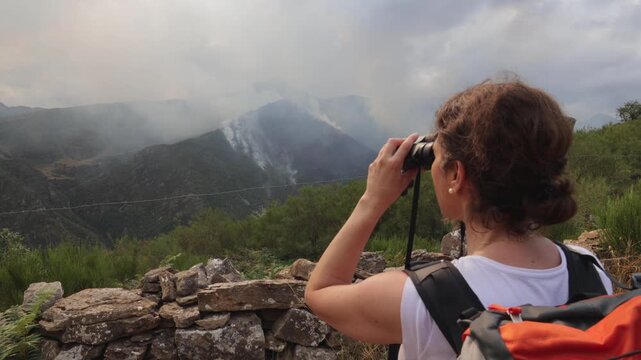 Female hiker exploring Somiedo Valley with binoculars