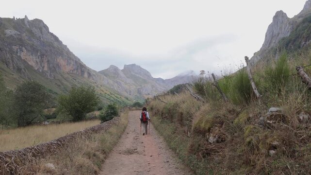 Female hiker on scenic mountain trail in Somiedo Valley
