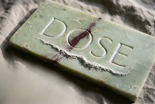 Handmade soap bar with dose engraving on soft fabric background