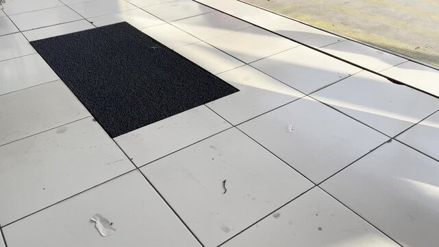 Cozy home interior ceramic floor with black doormat and warm sunlight video