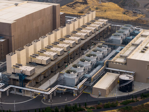 Aerial view of The Dalles Google Data Center featuring large industrial buildings, rows of cooling towers, and complex piping infrastructure in The Dalles, Oregon, United States.
