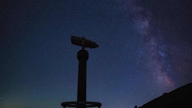 Night sky timelapse capturing the movement of the Milky Way galaxy, falling meteors, and satellite trails behind the silhouette of a panoramic viewing telescope on Babin Zub, Stara Planina mountain, S